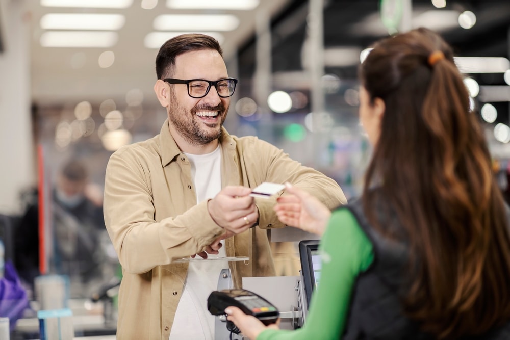 Happy customer paying for goods with credit card.