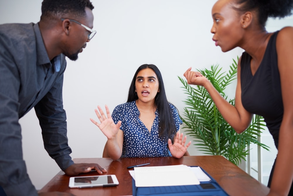 Woman trying to diffuse an argument between co-workers