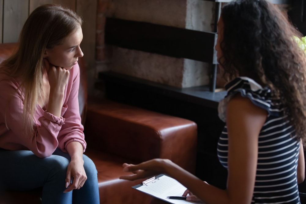 Young woman employee listening to constructive criticism