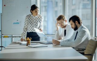 Bad job. Angry female boss having a meeting with her employees and reprimanding them for the poor performance while they looking embarrassed