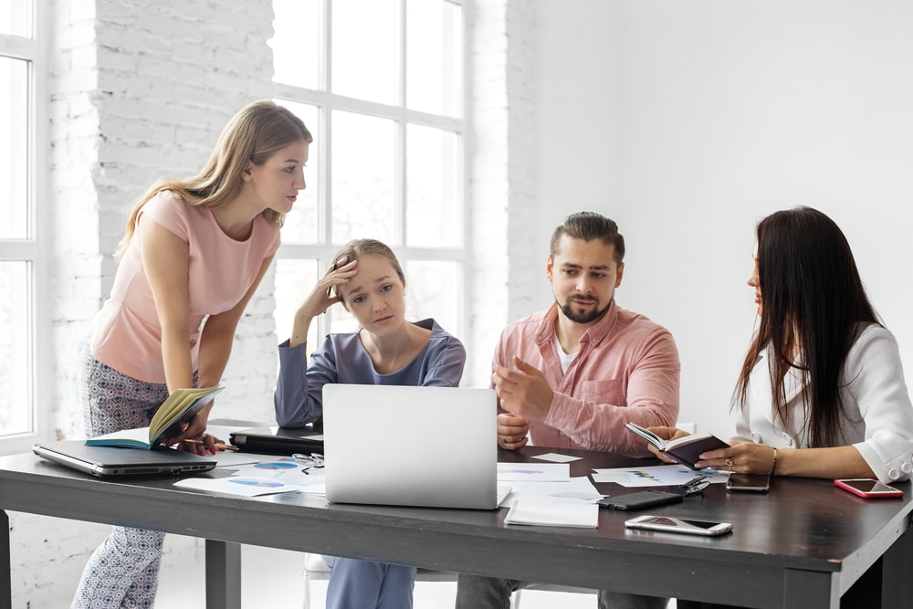 Saddened by poor work employees sitting at the table in a meeting in the office. Bankruptcy company. Concept for business, work, problems, bankruptcy and failure to fulfill a plan and tasks.