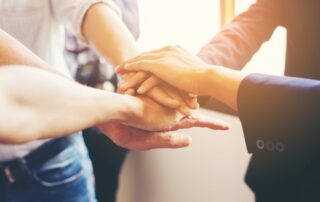 Concept of teamwork: Close-Up of hands business team showing unity with putting their hands together.