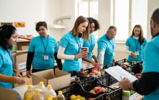 Nonprofit employees and volunteers working together to organize donated food, demonstrating teamwork, communication, and a positive workplace culture.